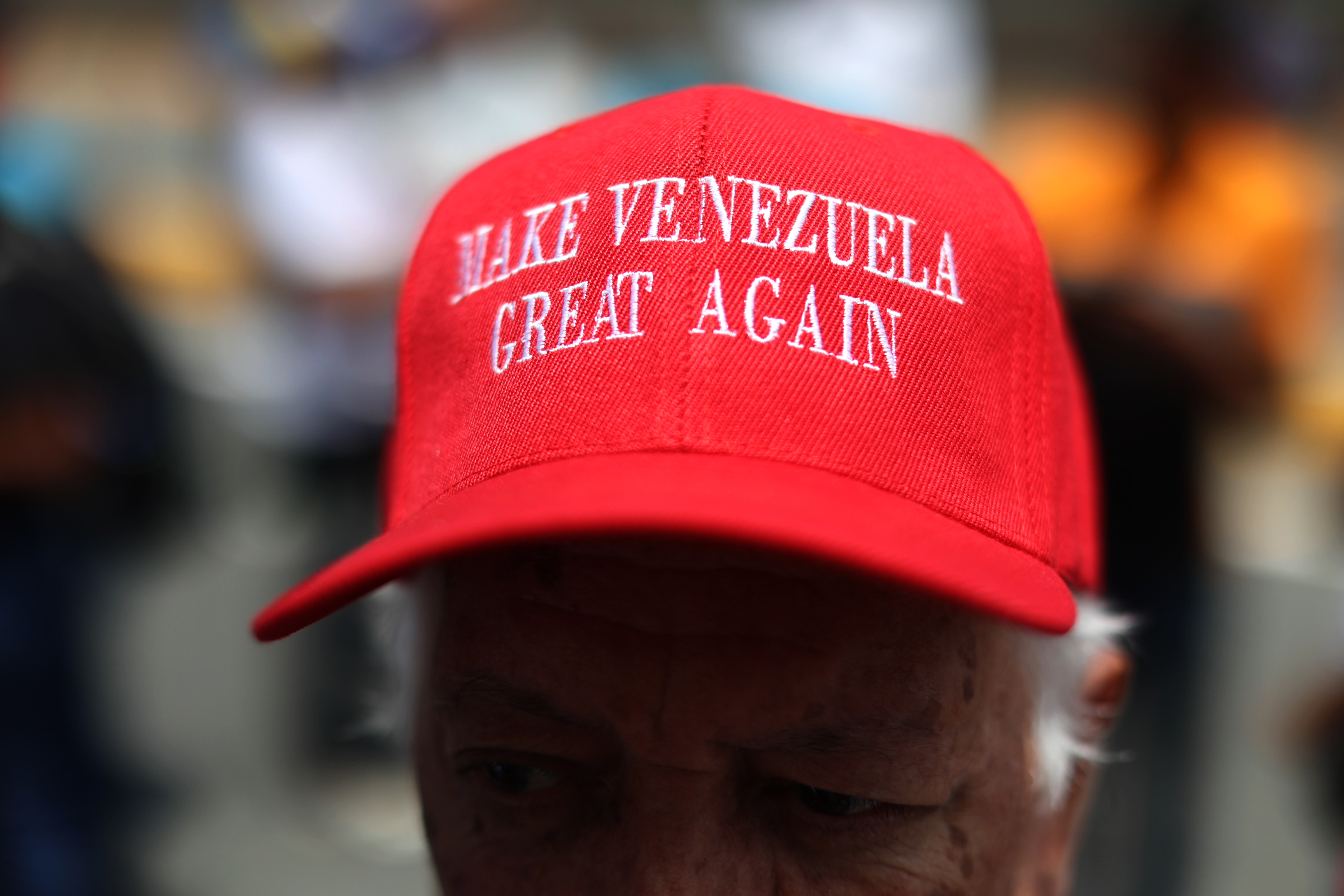Una hombre se concentra en Caracas con una gorra con un lema similar al del presidente Trump, pero referido a Venezuela.