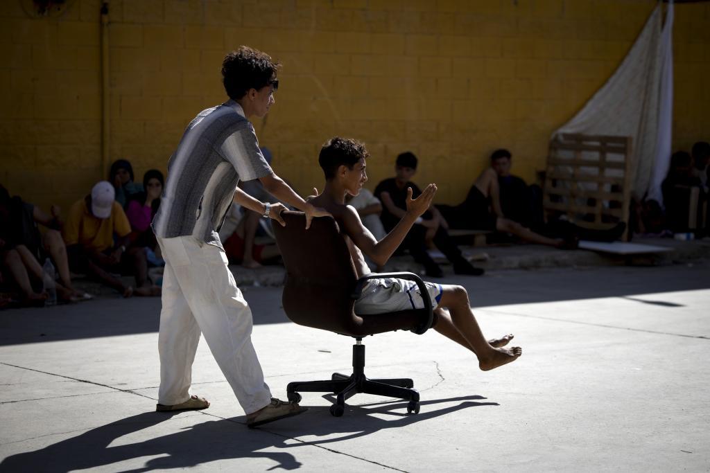 Dos adolescentes juegan con una silla de oficina en esta 'favela' de Ceuta.