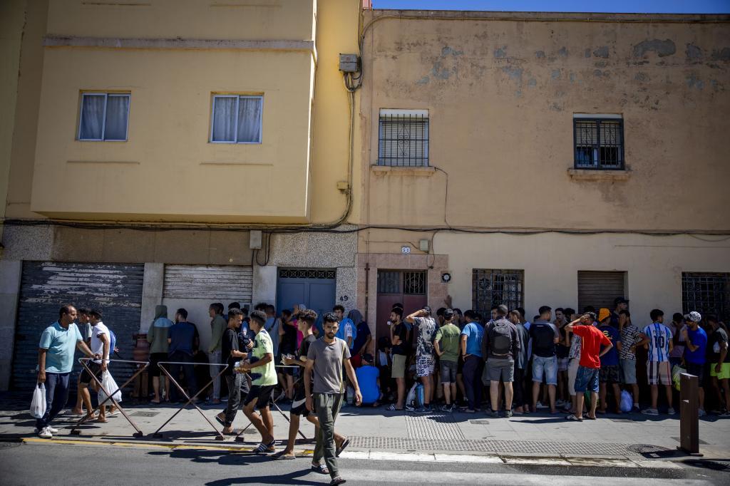 Cola de inmigrantes esperando para comer o ducharse en casa de Sabah.