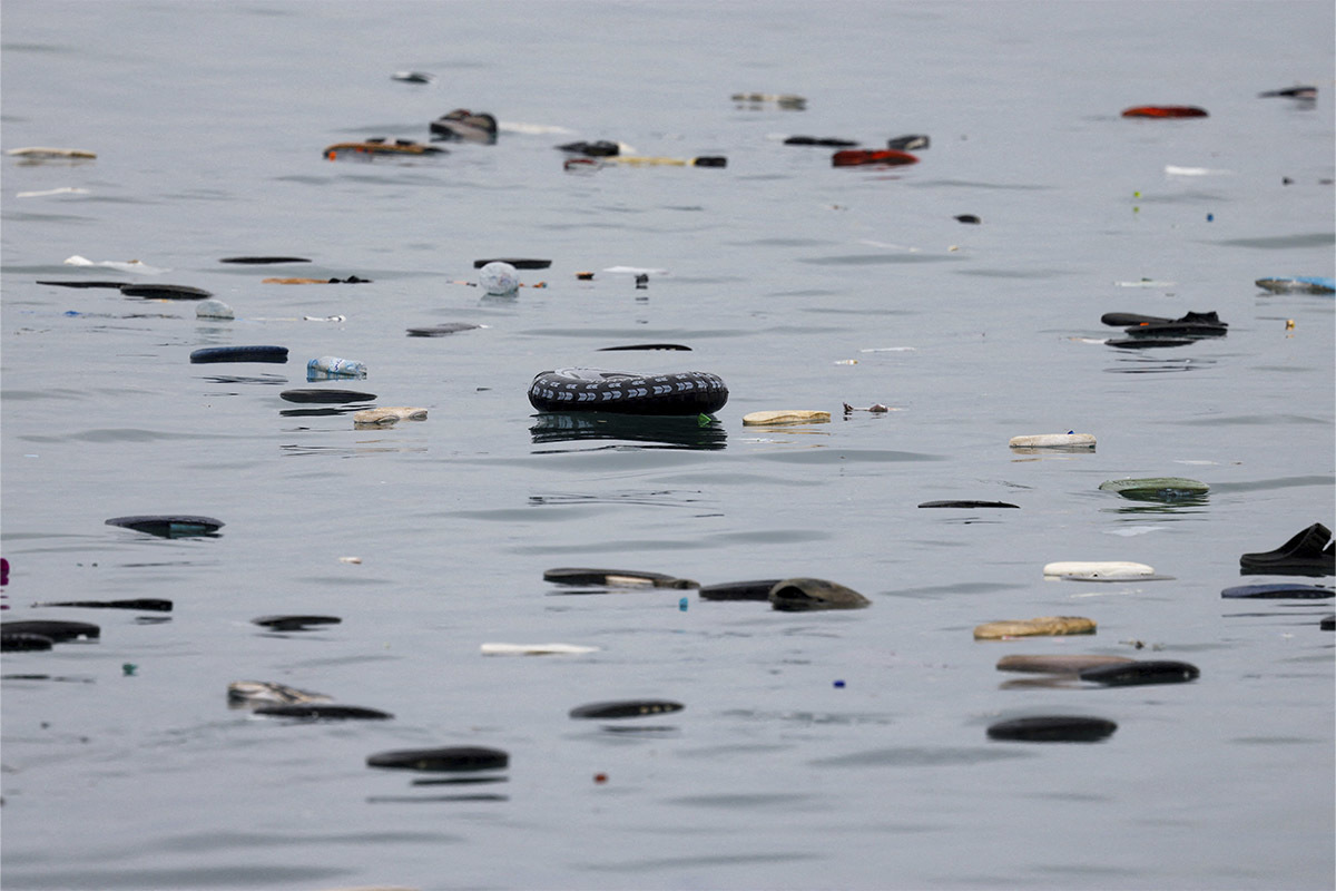 Un flotador destaca entre el calzado perdido por decenas de migrantes que cruzaron a nado la playa de El Tarajal para pasar de Marruecos a Ceuta.