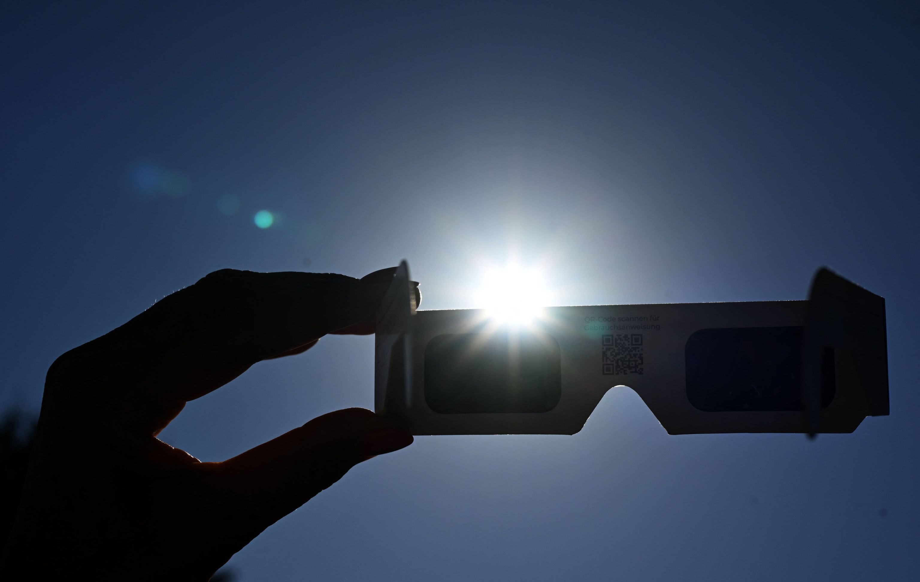 Una mujer usando gafas homologadas durante el eclipse total de Sol.