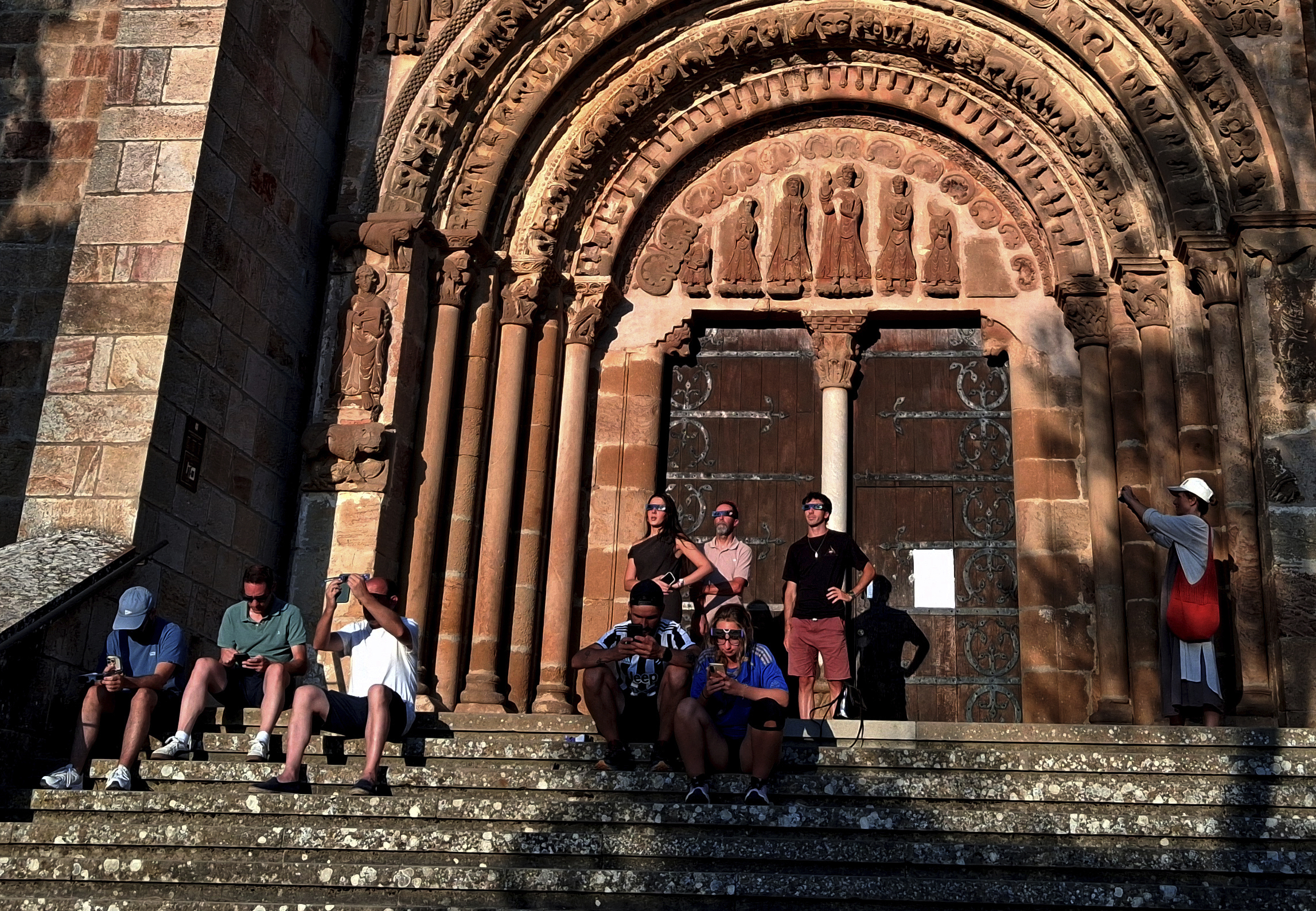Algunos turistas contemplan el eclipse en el monasterio benedictino de Leyre, en Navarra.