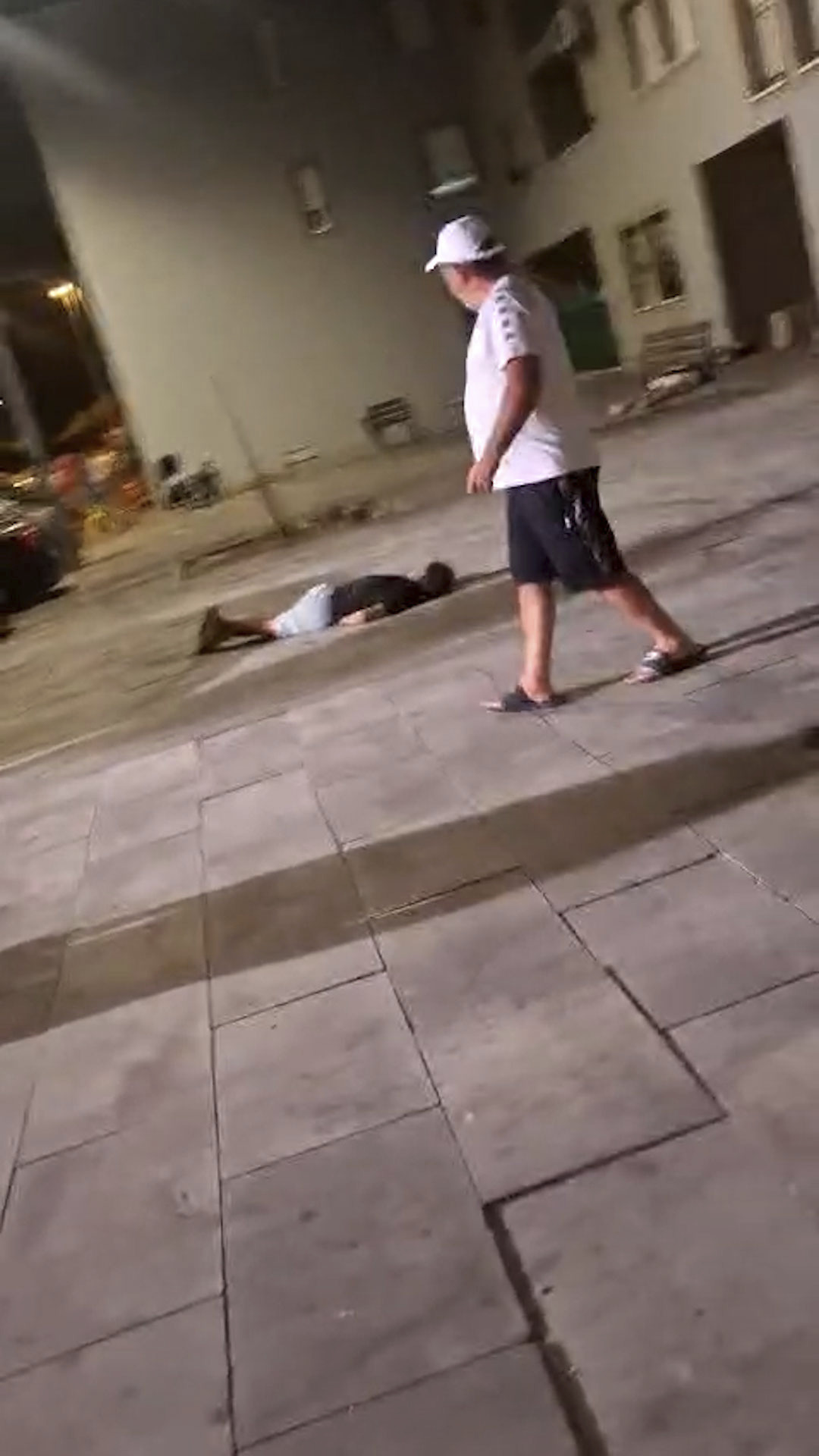 Un hombre pasa junto a uno de los cad�veres que ha dejado el tiroteo en Isla Cristina.