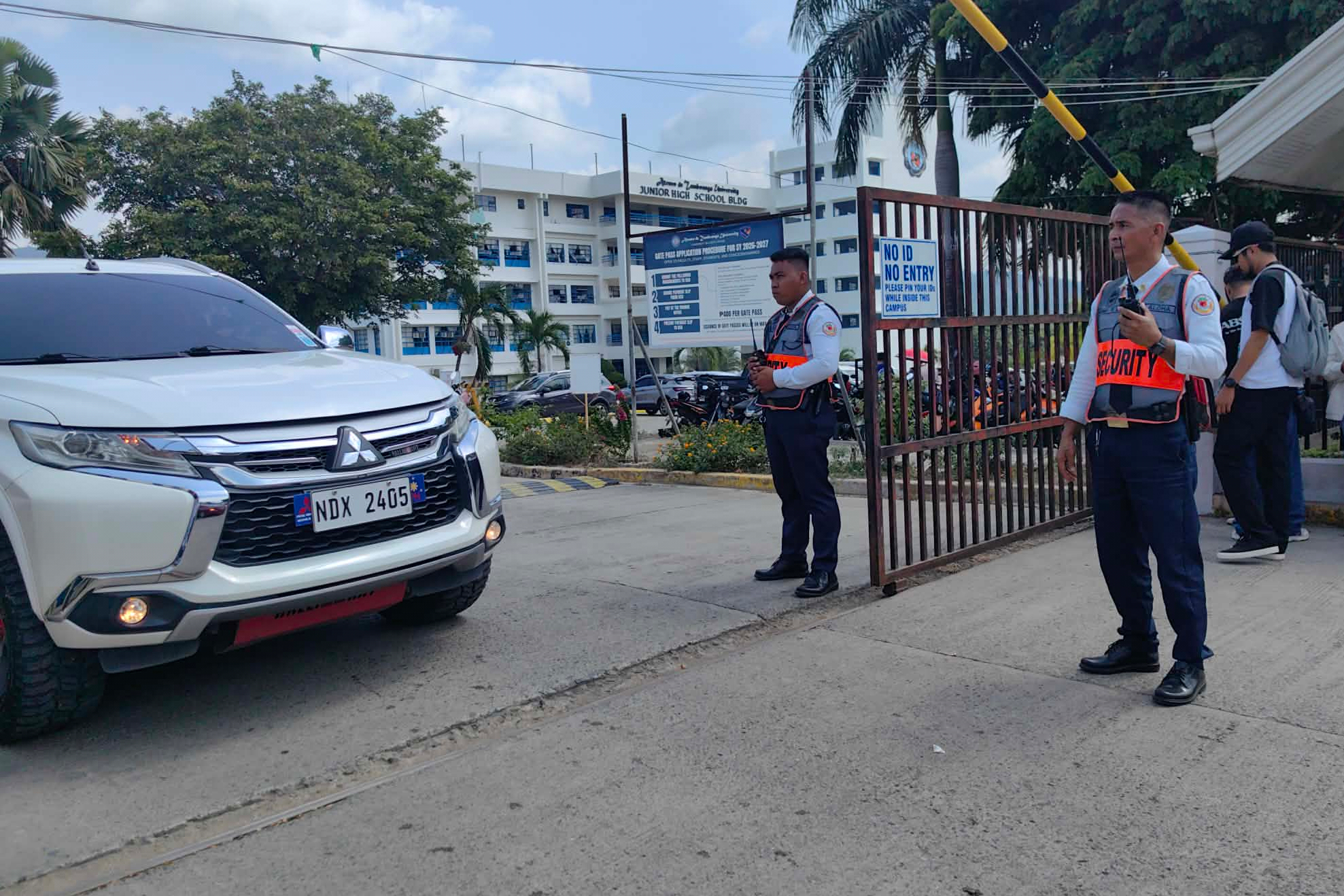 Guardias de seguridad observan la salida de vehículos de la Universidad Ateneo de Zamboanga tras un tiroteo este martes, en Zamboanga, en el sur de Filipinas.