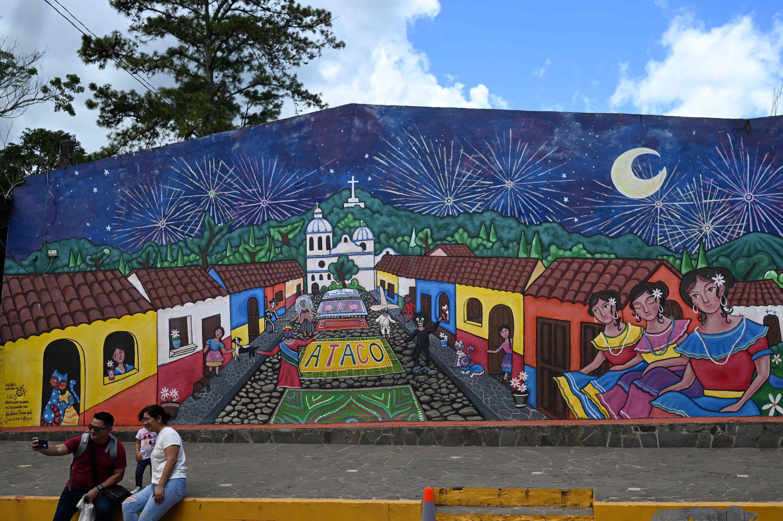 Una familia se fotografía frente a los murales en Concepción de Ataco.
