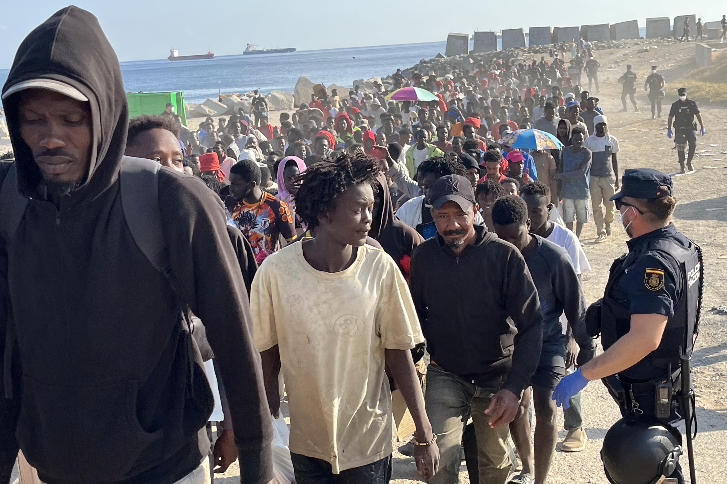 Migrantes son desalojados de la playa del Trampol�n en Ceuta.