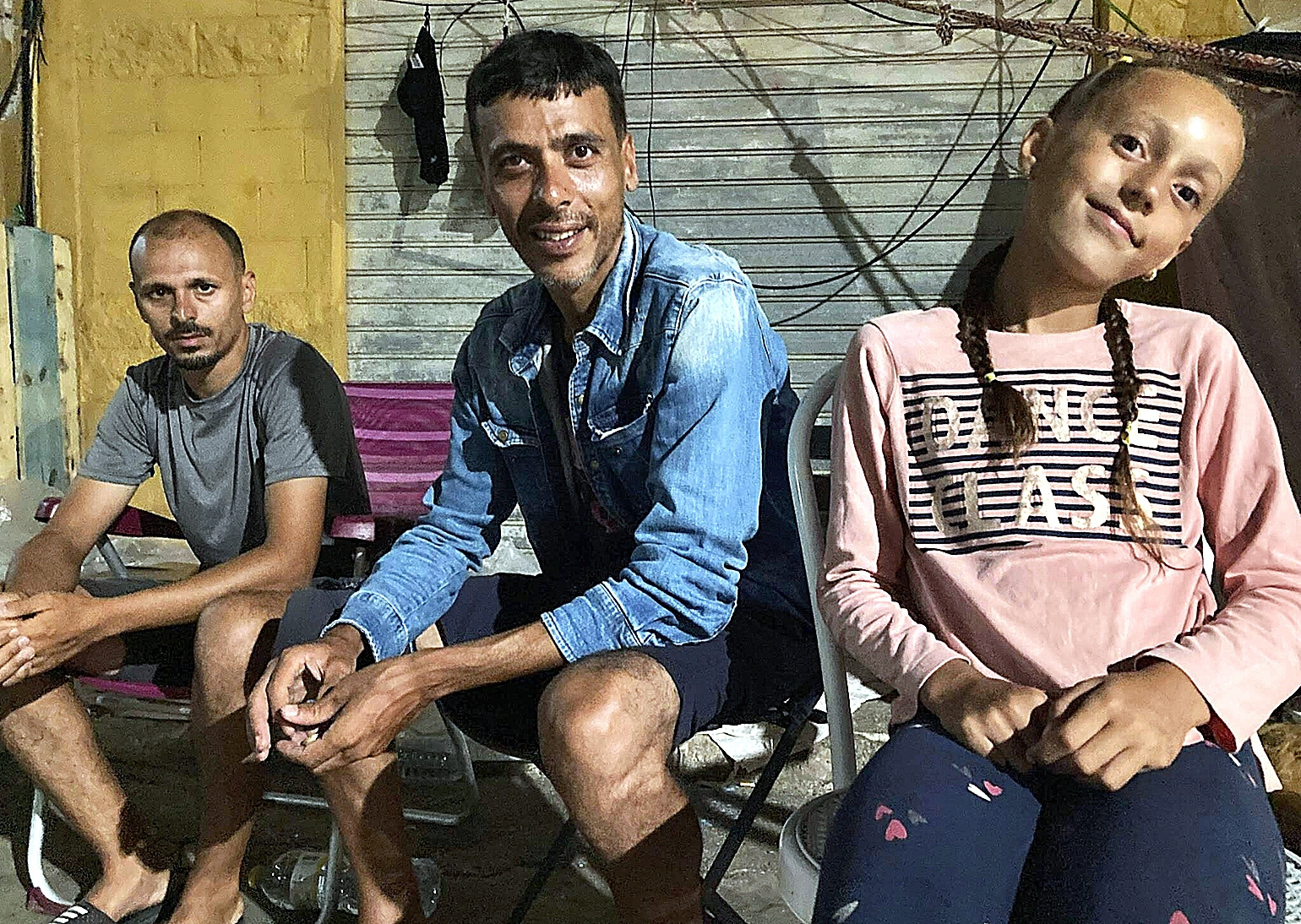 Mustafa, con su sobrina Ritaj a la derecha y su amigo Jouchal a la izquierda, en el pol�gono de El Tarajal el mi�rcoles por la noche.