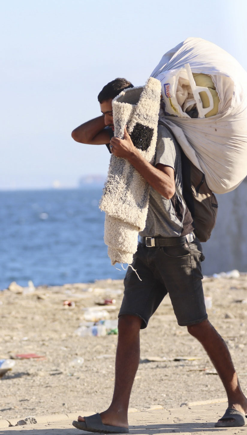 Un migrante se marcha del Trampolín, con sus pertenencias.