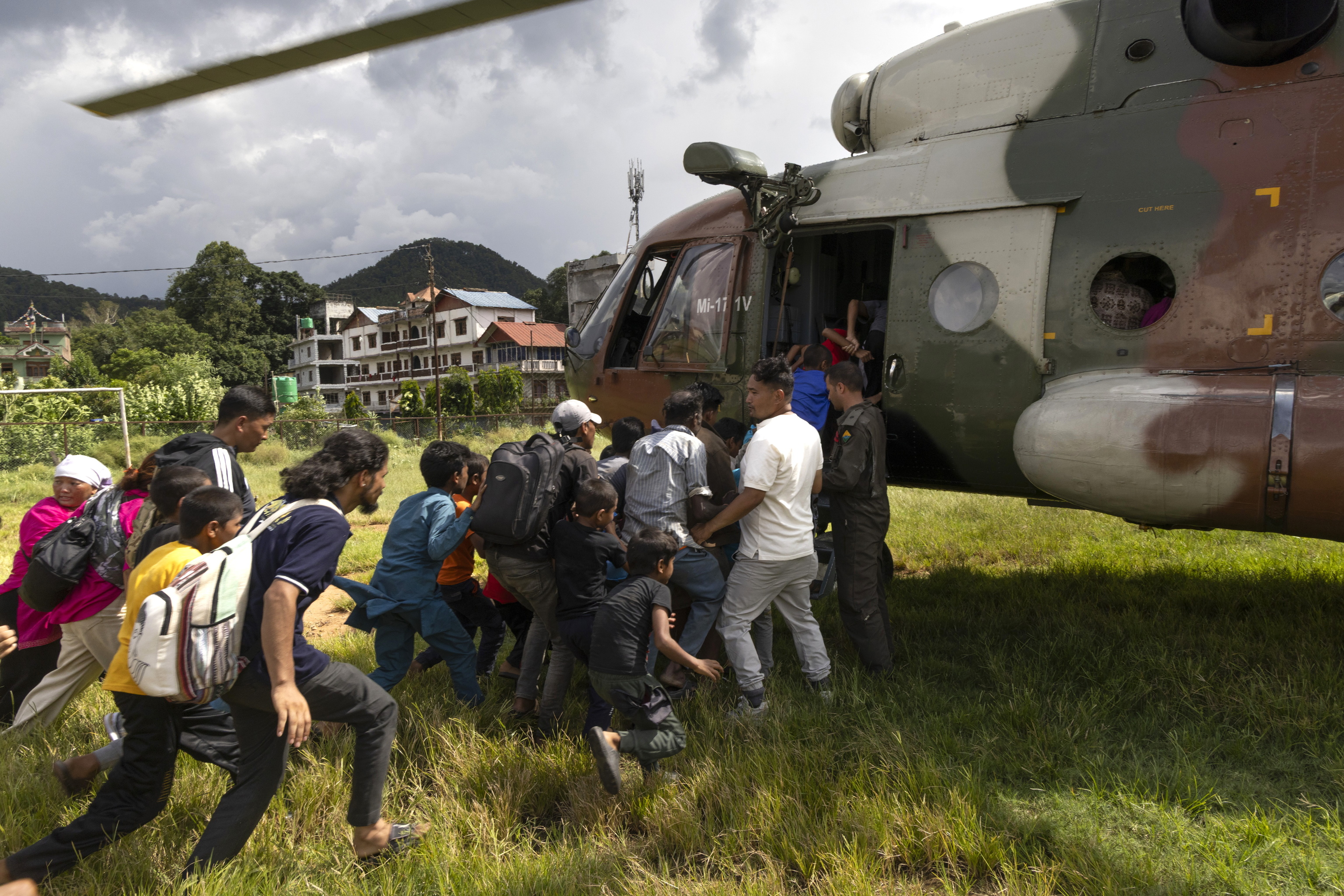 La gente corre hacia un helicóptero del Ejército de Nepal durante una operación de rescate tras las crecidas repentinas, en Hatigauda.