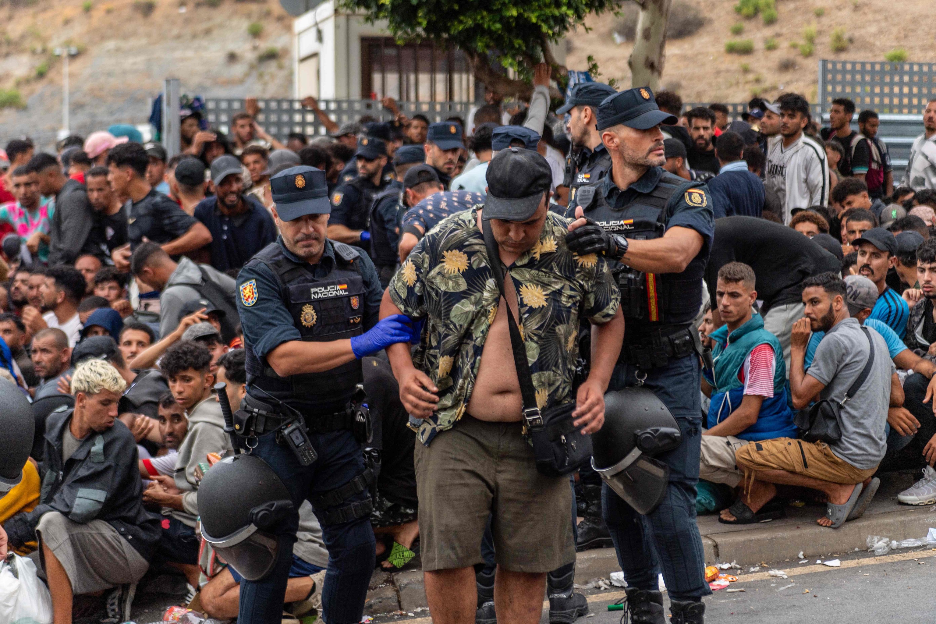 Agentes de la Policía Nacional trasladan a un inmigrante en Ceuta.