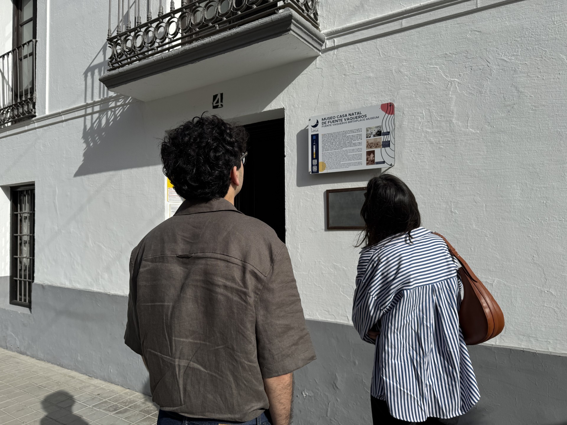 Dos jóvenes frente a la puerta de la casa natal de Federico Garcia Lorca en Fuente Vaqueros.
