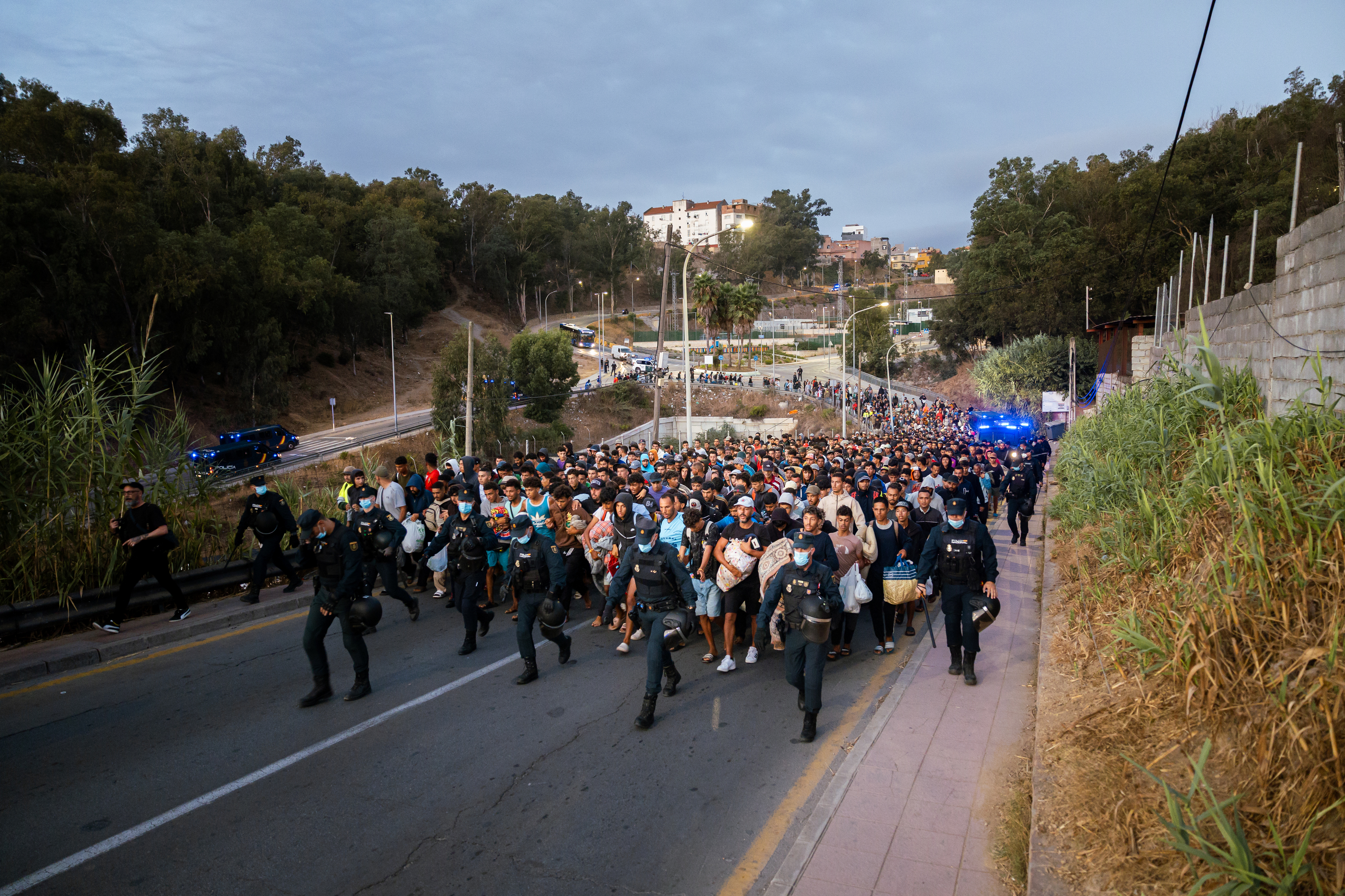 La Policía traslada a los inmigrantes por las calles de Ceuta.