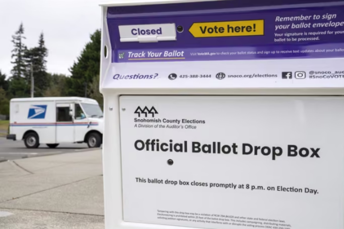 Un camión del Servicio Postal de Estados Unidos aparcado cerca de un buzón de depósito de votos en la localidad de Brier, estado de Washington.
