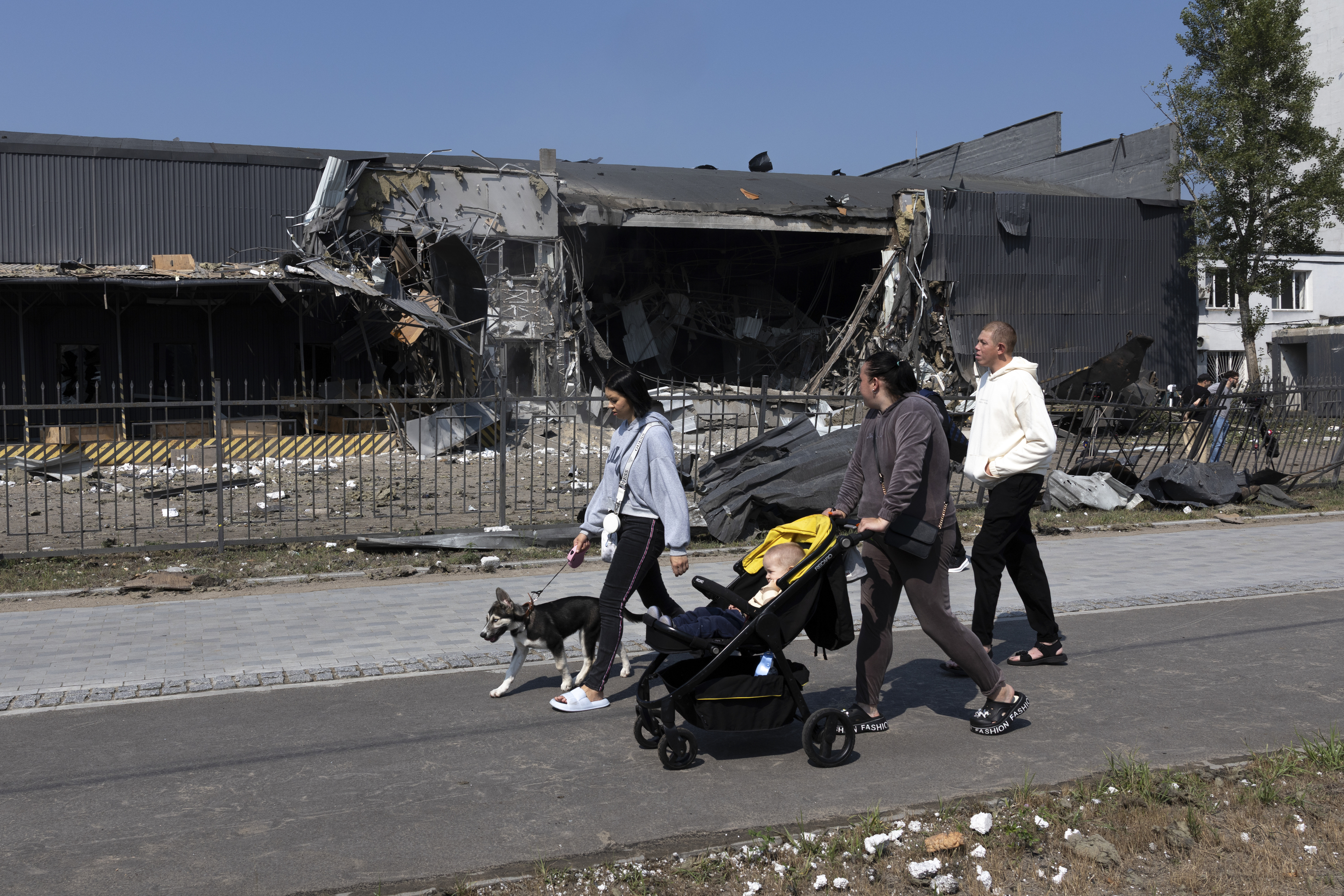 Unos residentes pasan junto a un centro de la empresa Nova Poshta, atacado con misiles balísticos rusos en Kiev.