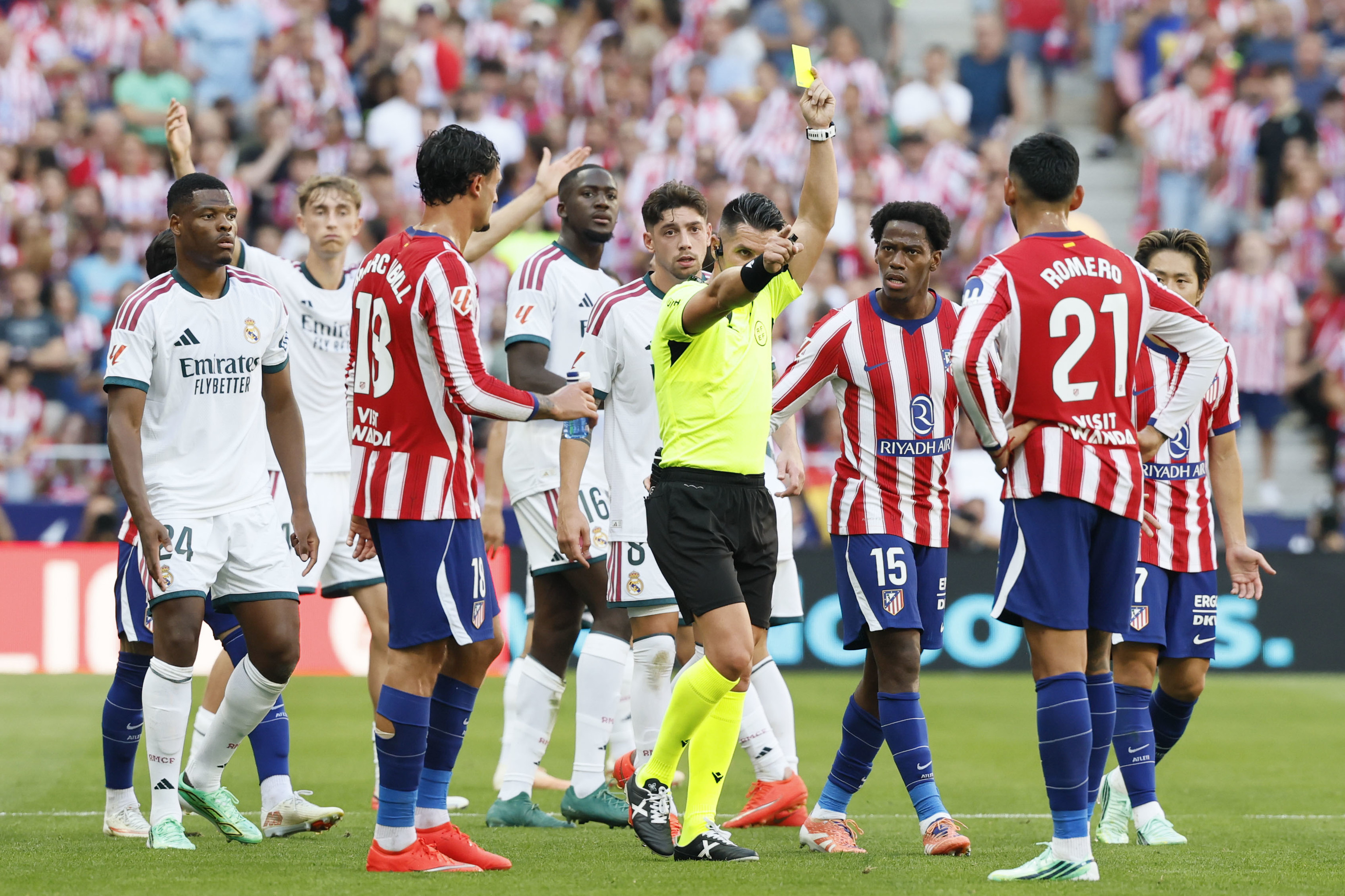 El árbitro Miguel Ángel Ortiz Arias enseña la amarilla al 'Cuti' Romero pese a revisar en el VAR un plantillazo en la rodilla de Bellingham.