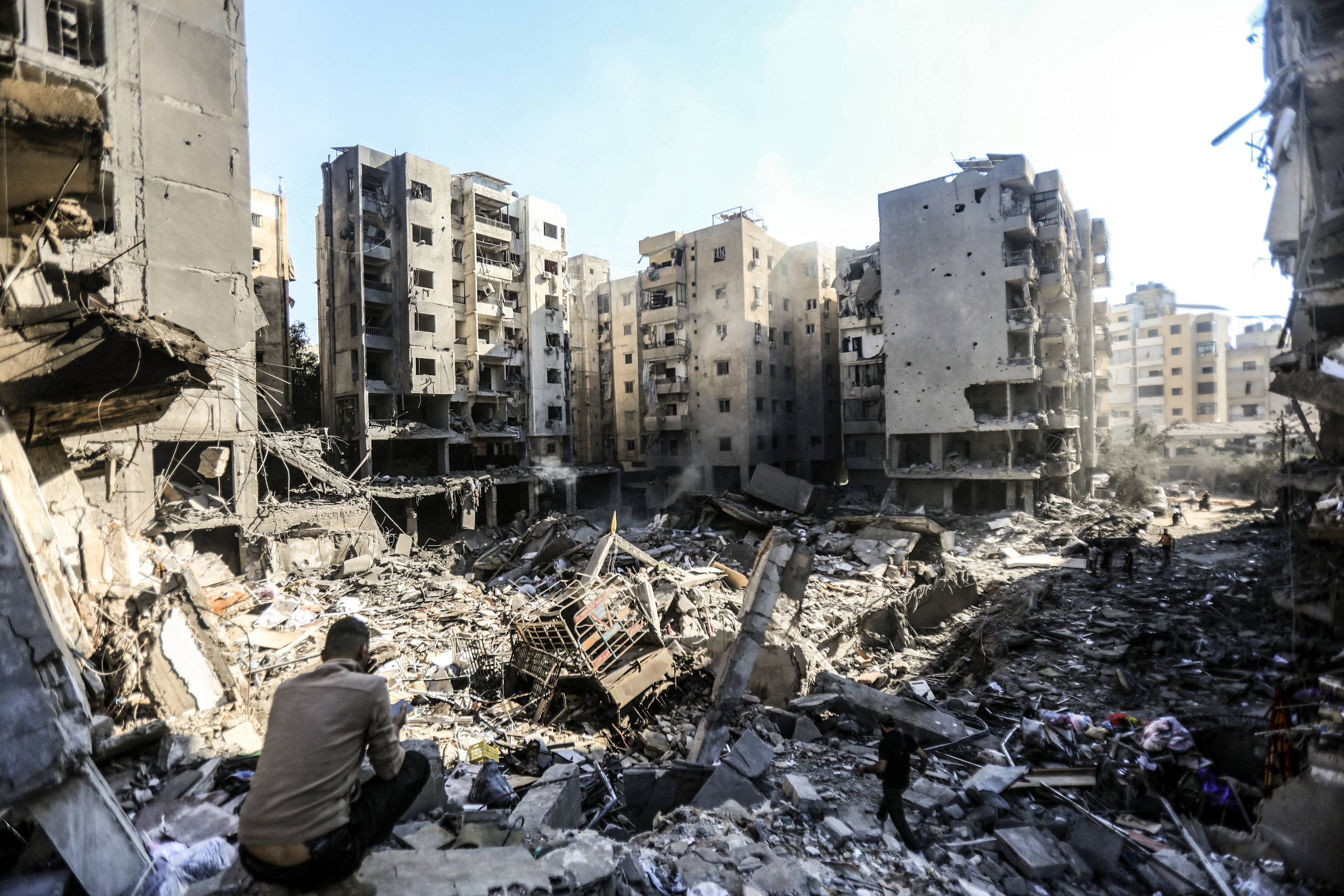 Las personas inspeccionan entre los edificios arrasados el 27 de septiembre por ataques israelíes.