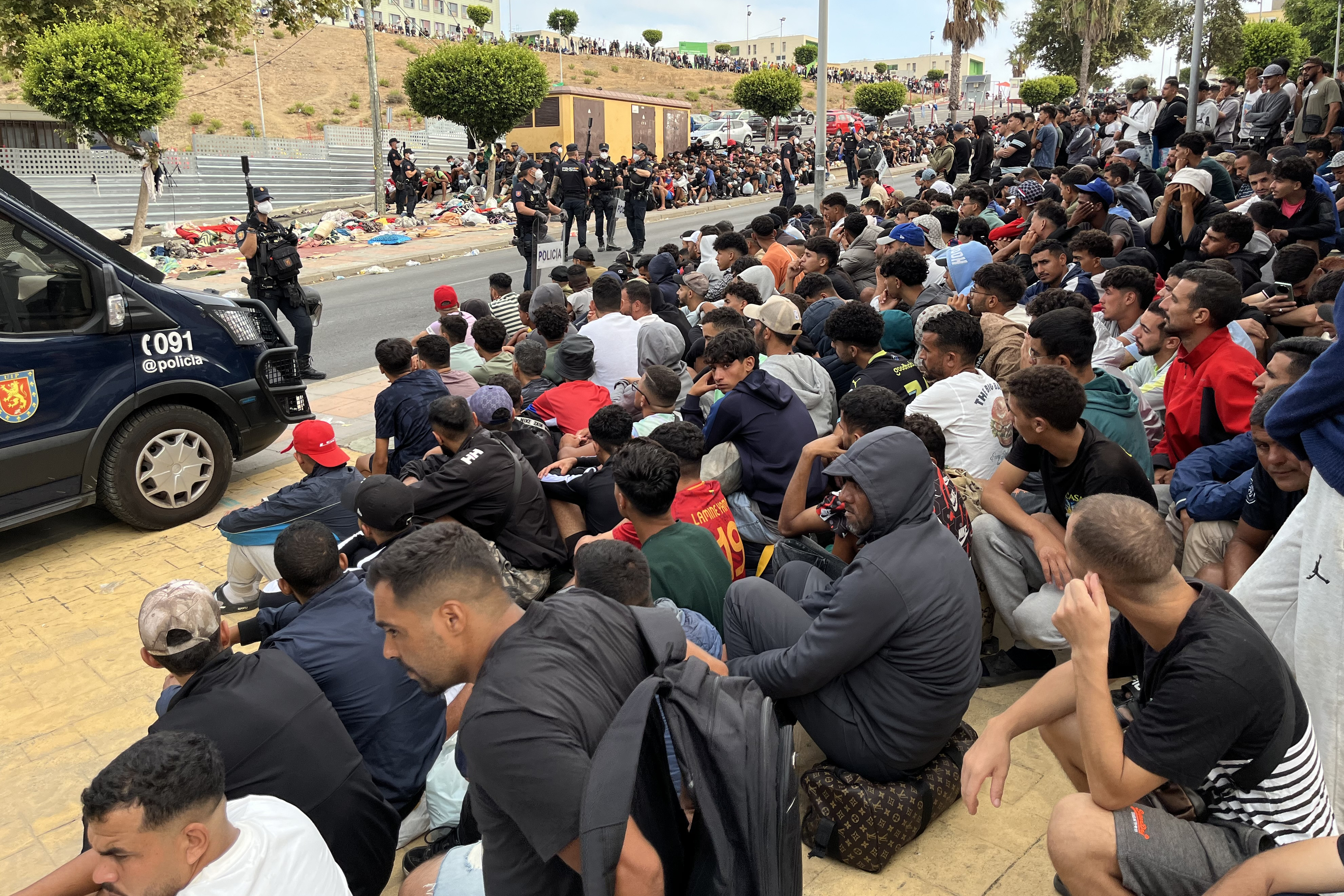 Un grupo de inmigrantes es controlado por la Policía en Ceuta tras la invasión que sufrió la ciudad autónomo el pasado mes de julio.