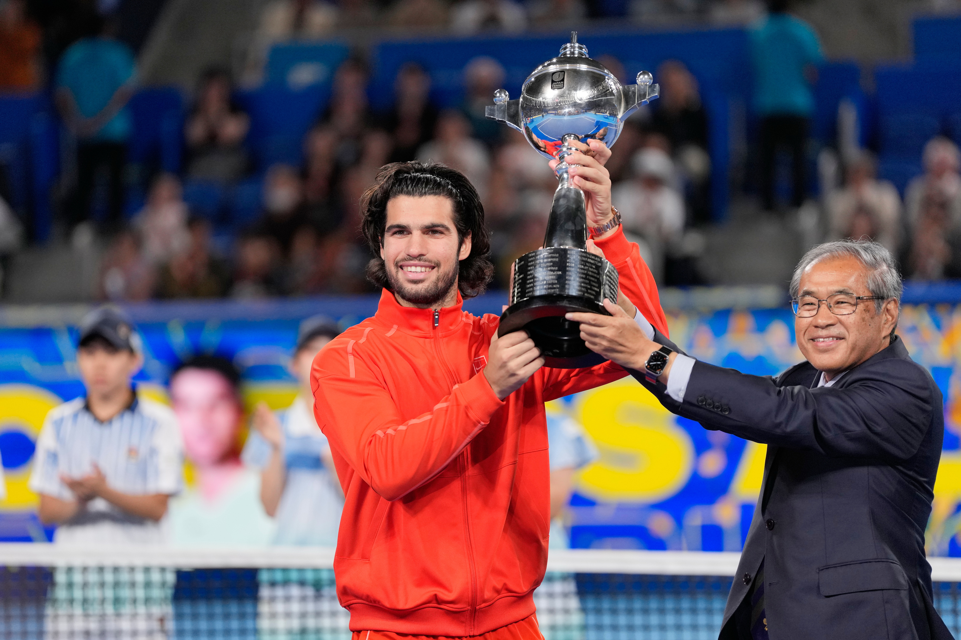 Alcaraz levanta el trofeo, en Tokio.
