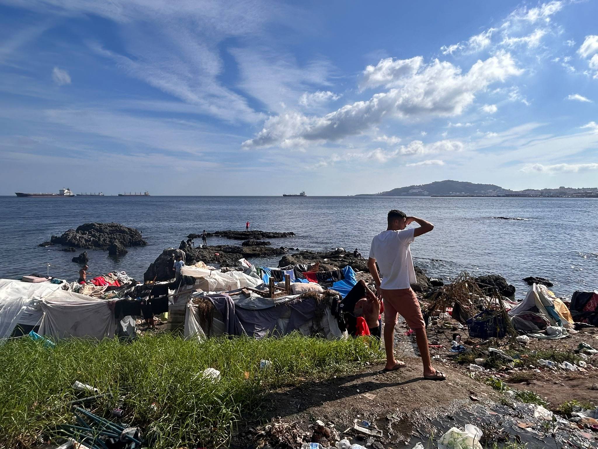 Un migrante mira al horizonte junto a las chabolas montadas en la playa en el Guano.